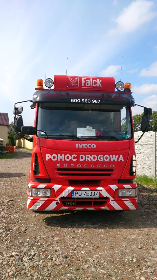 Czerwona ciężarówka zaparkowana na polnej drodze w pobliżu Holownik.
