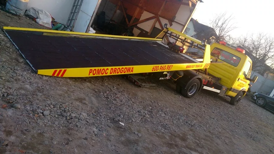 Przed domem zaparkowana jest ciężarówka holowniki.
