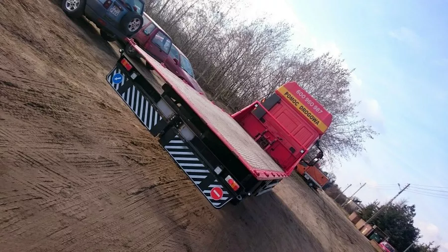 Holowniki zaparkowane są przy polnej drodze.