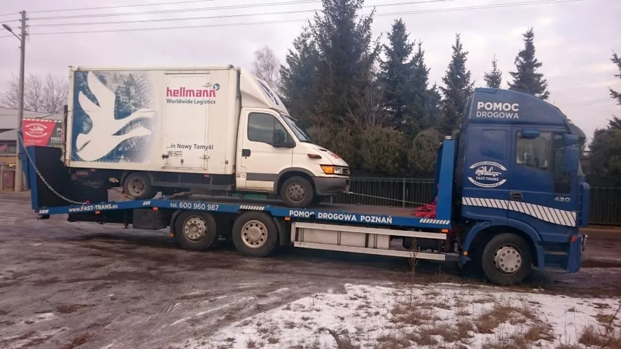 Niebieska ciężarówka z białym vanem z tyłu, zwana „holownikami”.