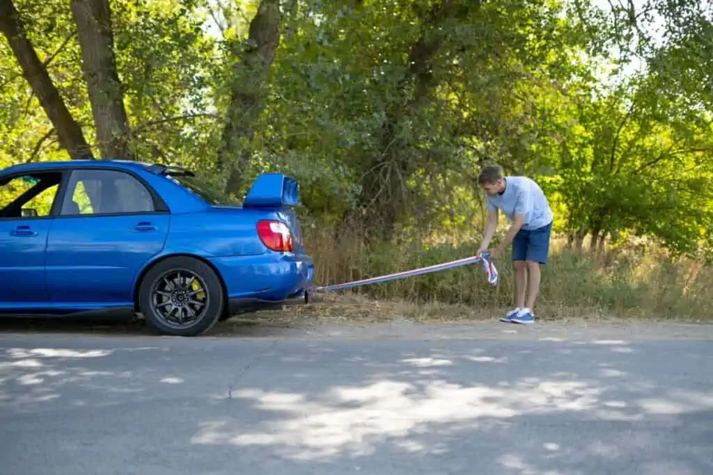 mężczyzna trzyma linkę do holowania auta