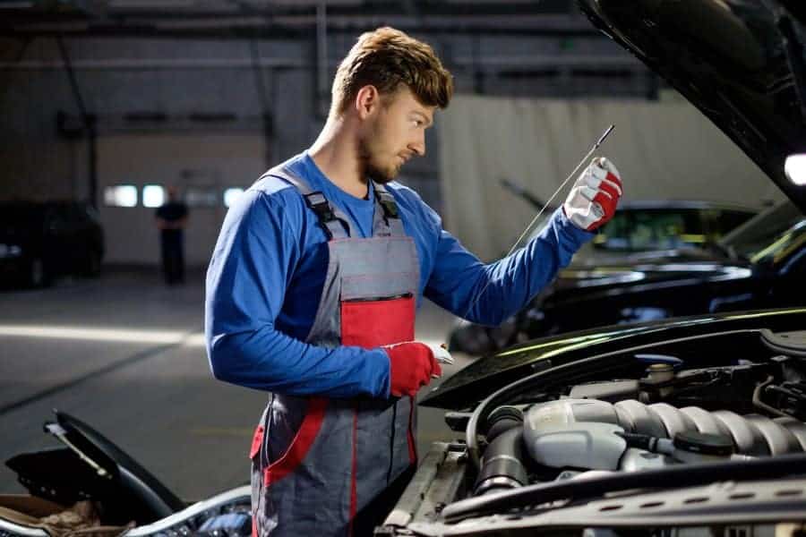 Mechanik sprawdzający silnik samochodu.