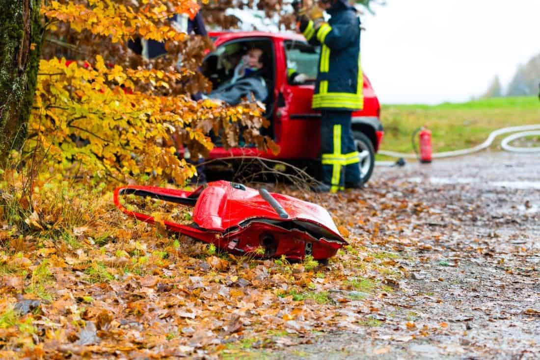 Czerwony samochód z gaśnicą na poboczu drogi.