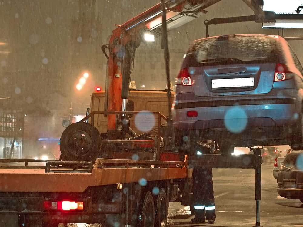 Samochód jest ładowany na platformę w nocy.